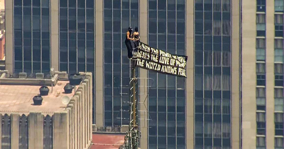 Man and woman detained after climbing Empire State Building with peace banner